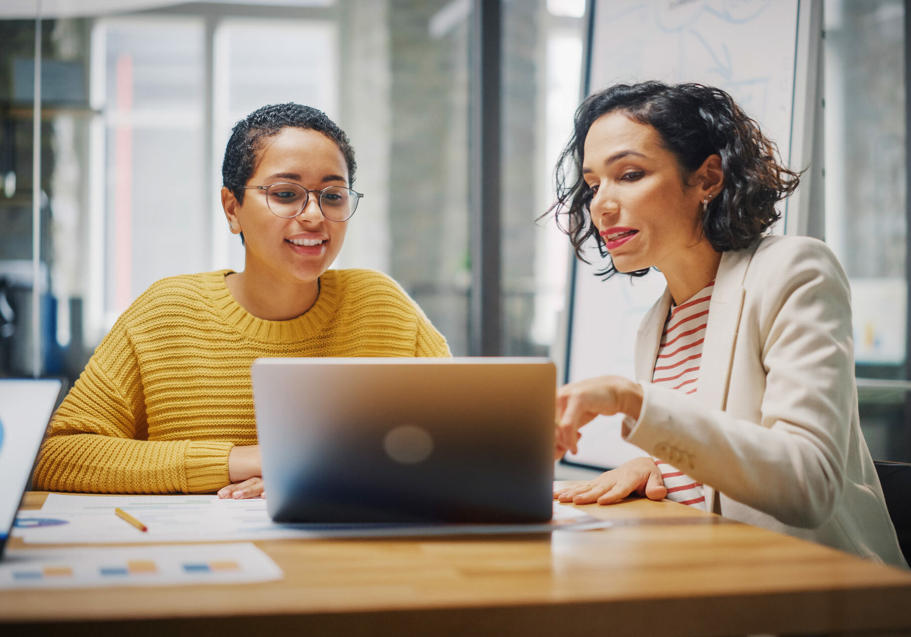 Two people at table looking at laptop