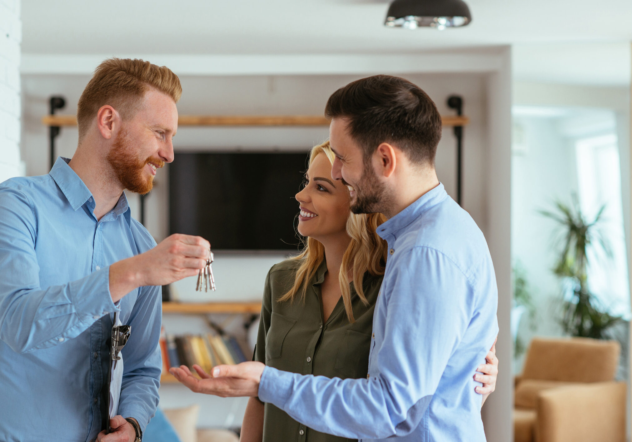 Real estate agent handing over the key to the happy couple